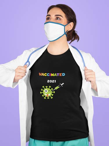 Frau mit Mundschutz und schwarzem T-Shirt mit buntem Schriftzug VACCINATED. Darunter Virus Zeichnung mit Spritze
